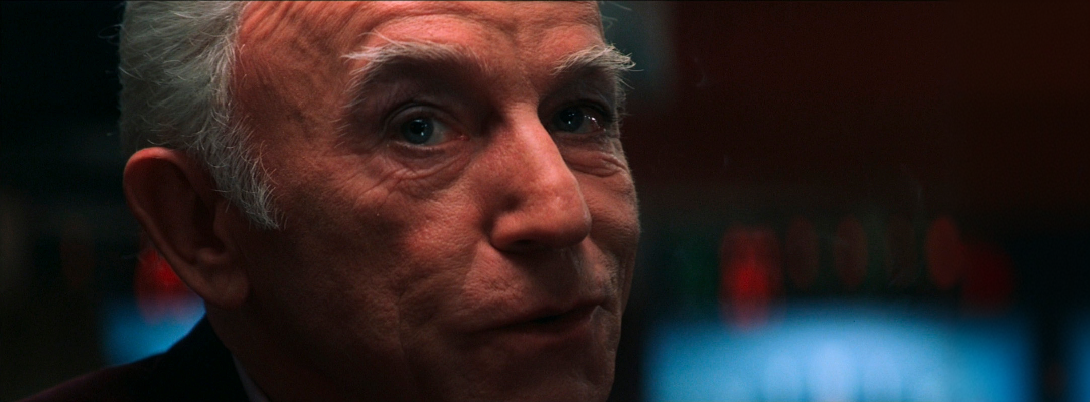 A weathered man looking toward camera